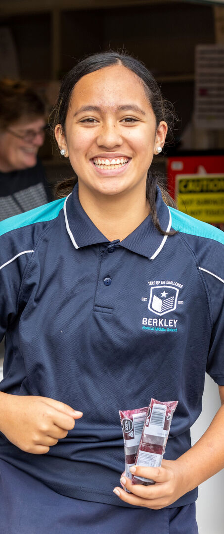 Student Smiles While Holding Snacks at the School Canteen