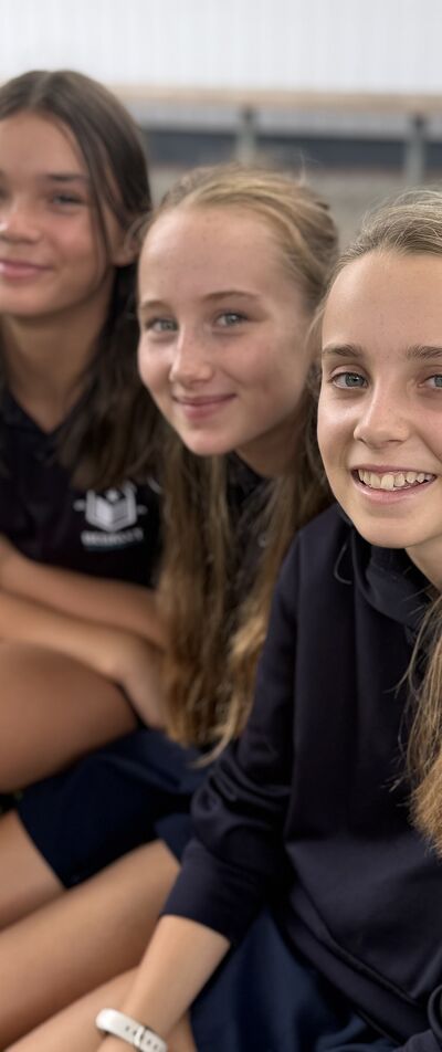 Three Students Sit Together on a Bench