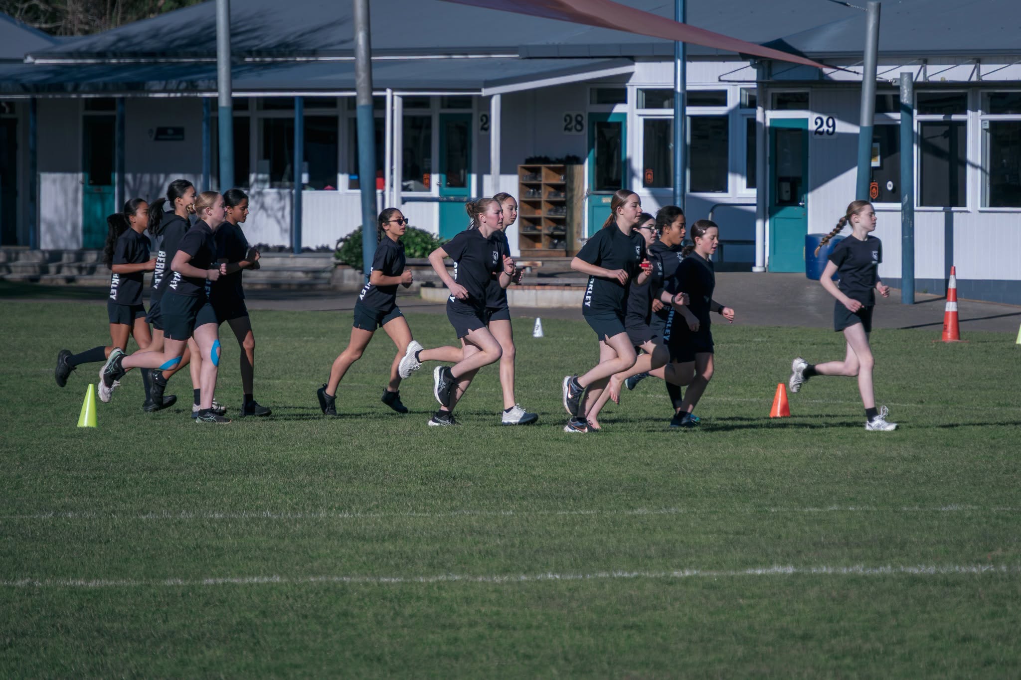 A group of Berkley students running together across the school field