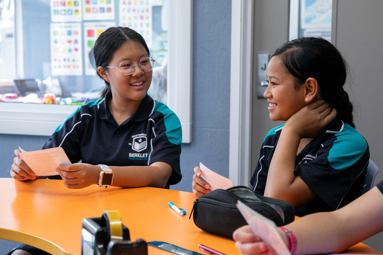 Two Berkley students smiling and learning together in class