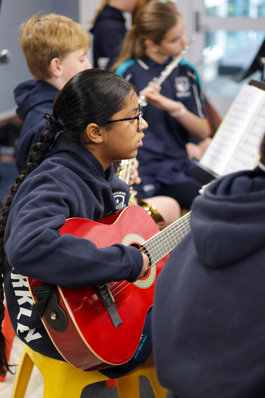 A Berkley student playing guitar during music