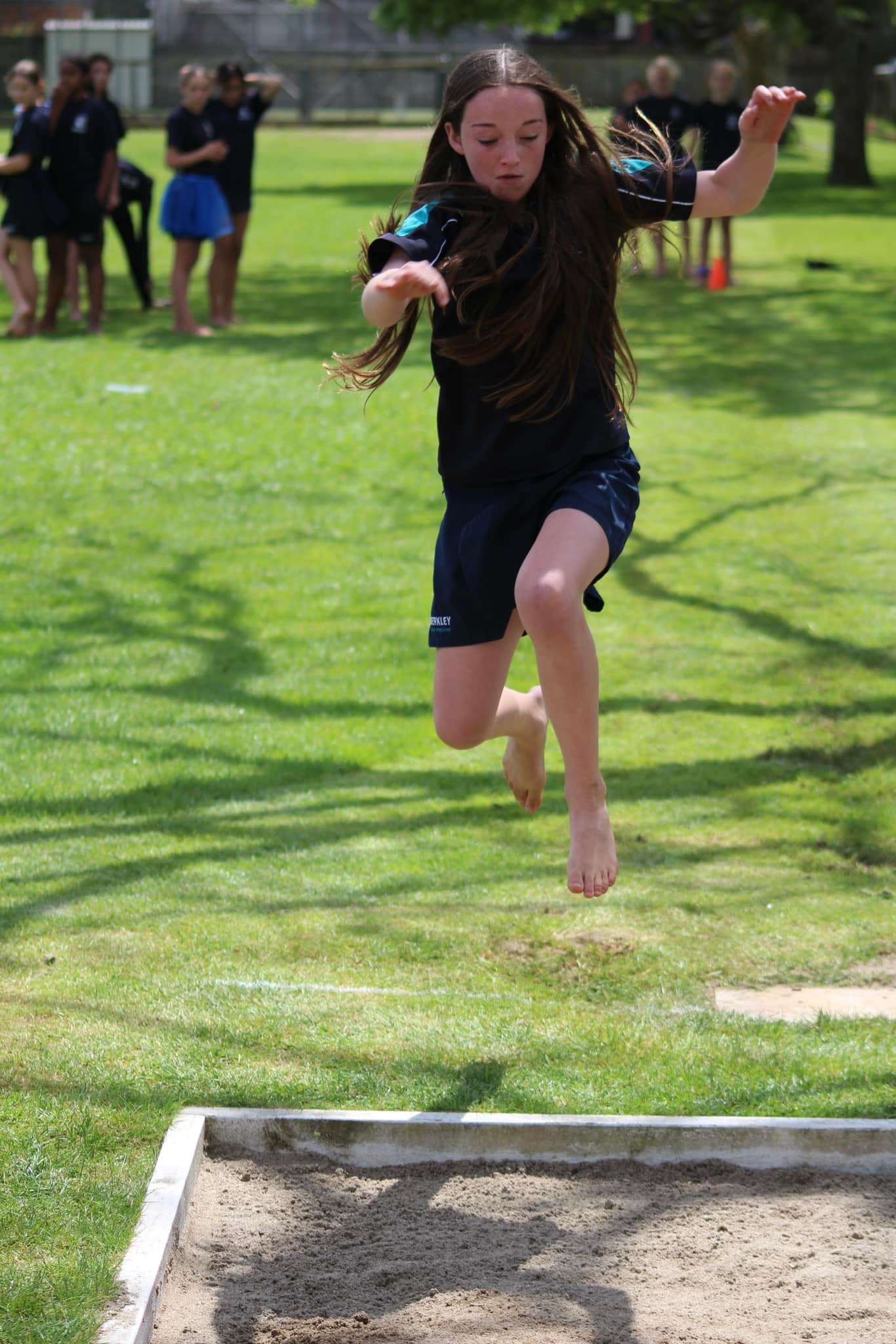 A Berkley student in mid-air during a long jump